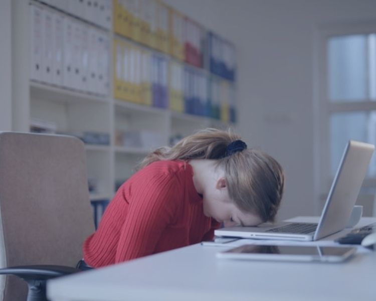 woman tired with her head on a laptop